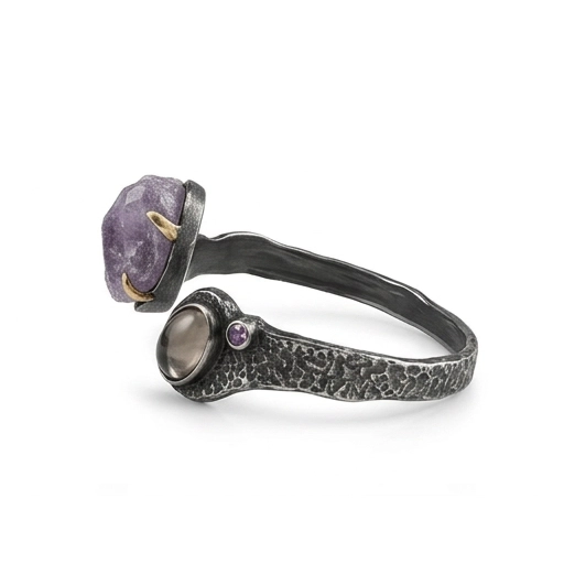 Side view of the bypass cuff bracelet, showing the ends with raw amethyst and cabochon passing each other
