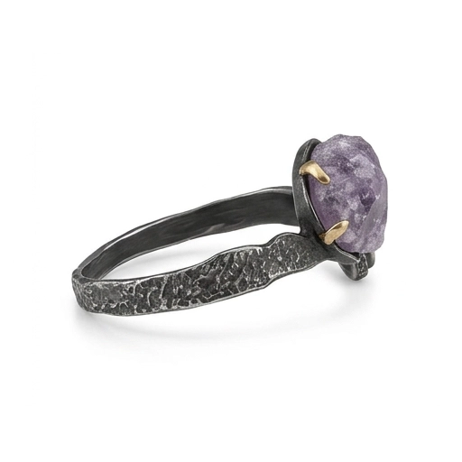 Side view of the black rhodium sterling silver cuff with its hammered texture and the raw amethyst at the end