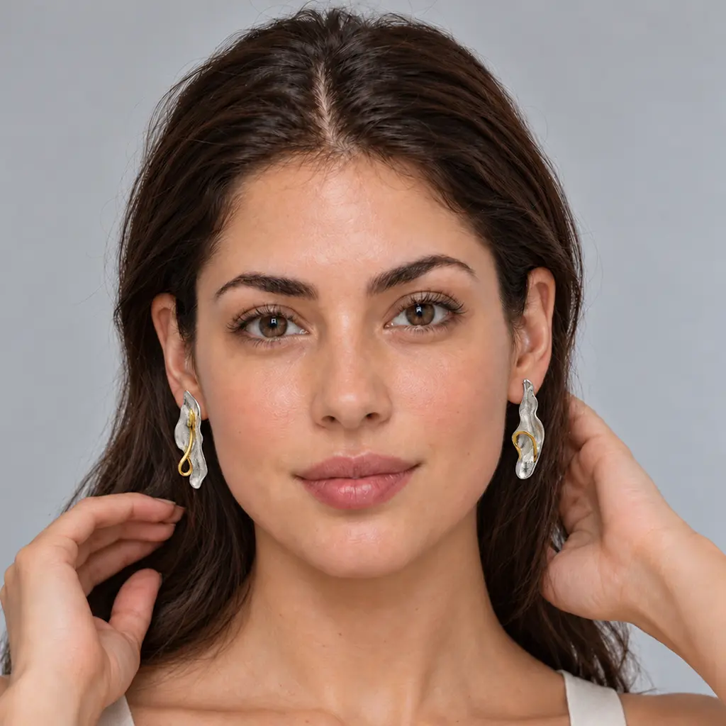 Woman wearing long two-tone silver and gold leaf earrings on posts, front view