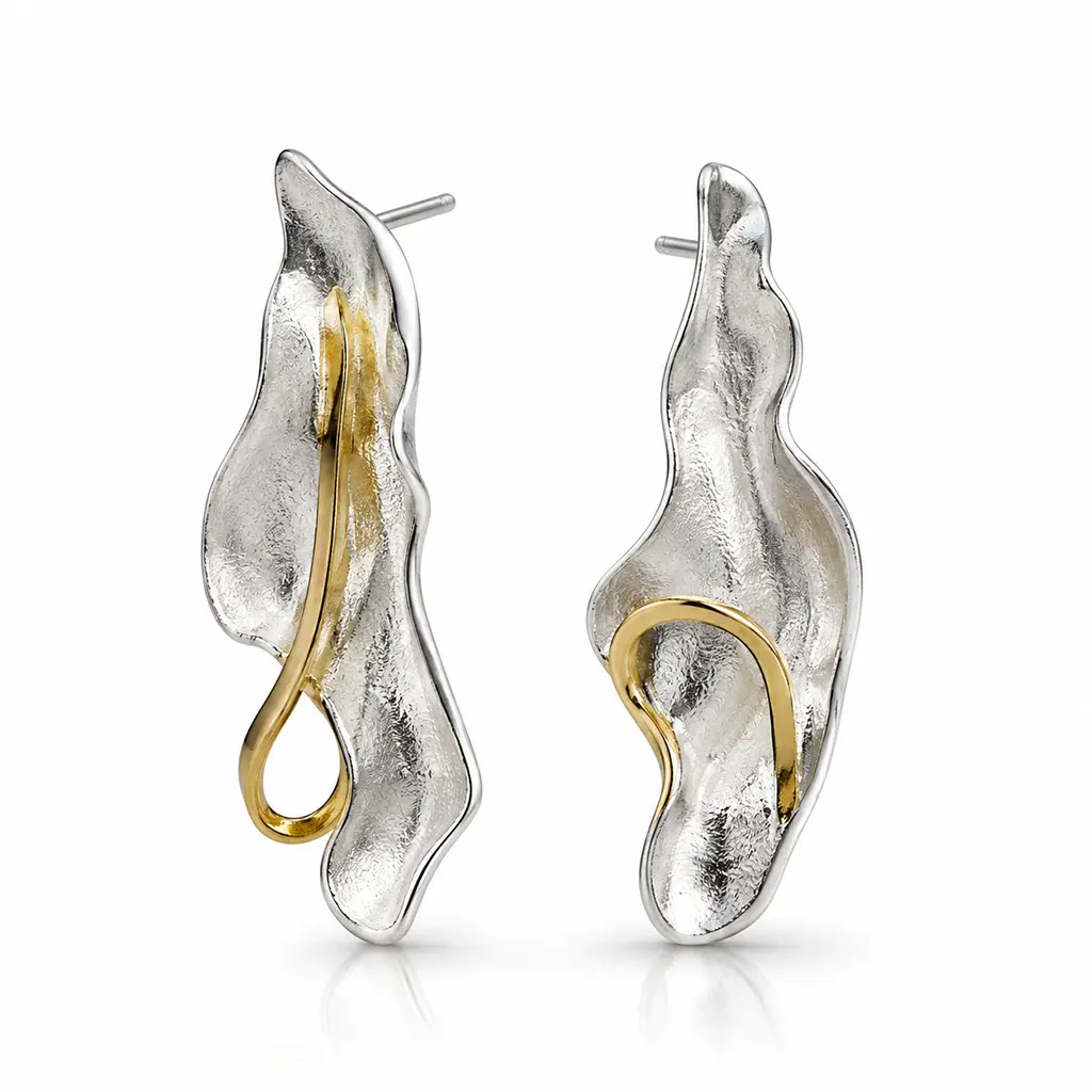 Mismatched sterling silver leaf drop earrings with gold plated curls and posts, brushed finish, on a white background